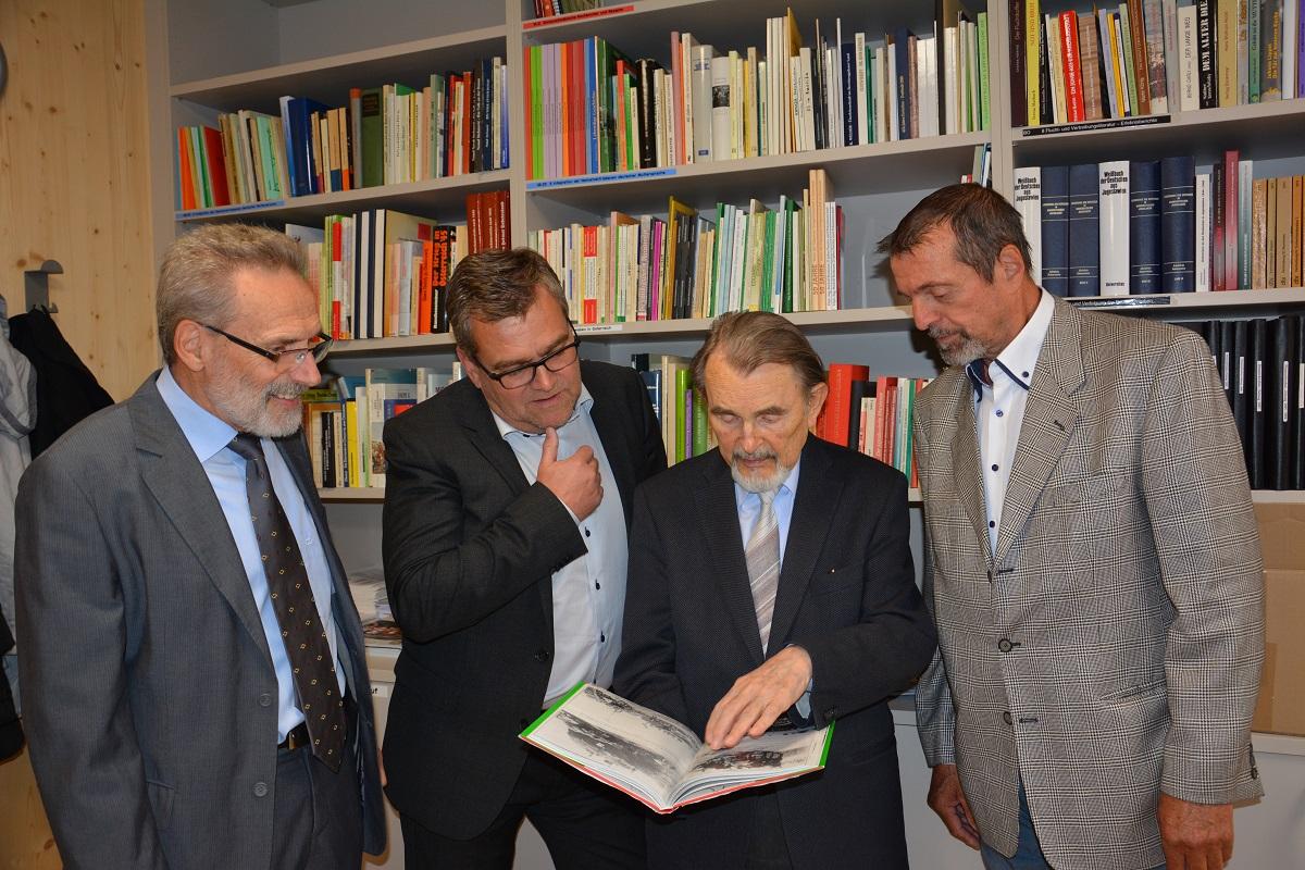 In der Bibliothek 2 Neller, Mahr, Wildmann mit Buch erklärend, Weinzierl
